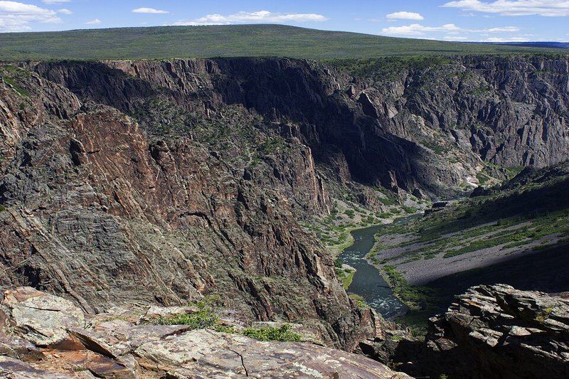 Deep narrow gorge of Black Canyon of the Gunnison with dark rock walls
