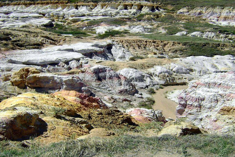 Colorful eroded rock formations with bands of white, purple, and orange