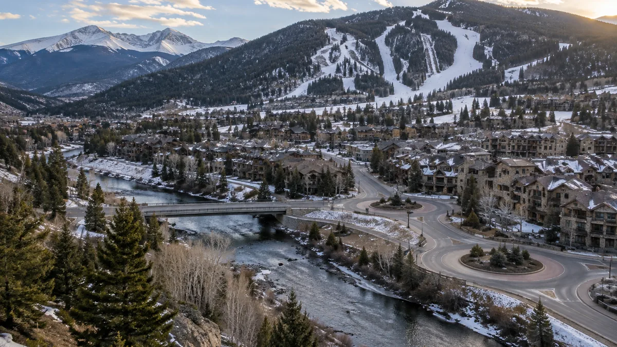 Roundabouts and a road bridge over the Eagle River in Avon, with condominium buildings and ski runs on the mountain behind