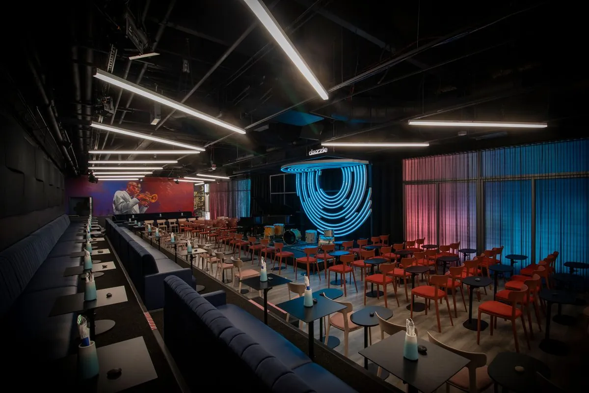 Dazzle Denver main listening room with blue neon stage backdrop and intimate jazz club seating