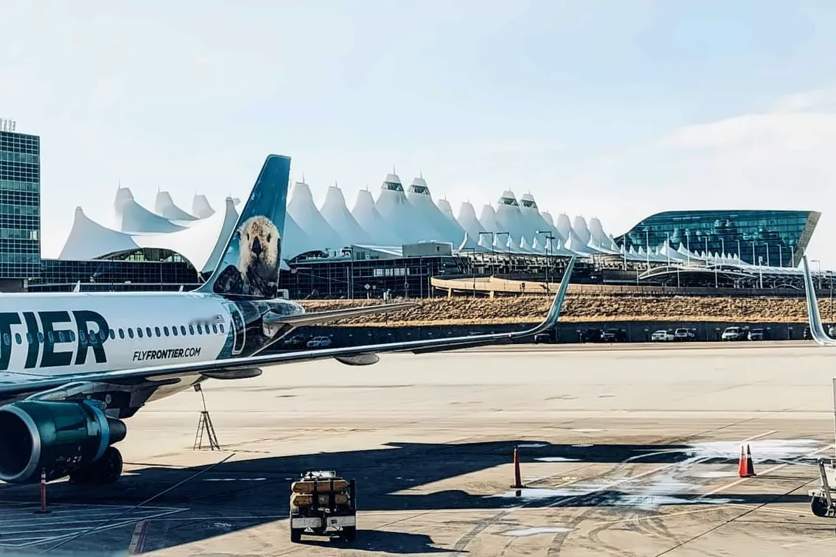 Frontier jet on the ramp at Denver International with the Jeppesen Terminal tent roof behind