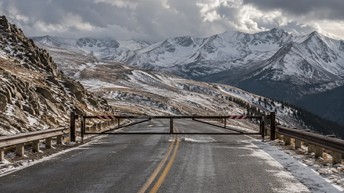 A closed gate on Independence Pass above Aspen with snow on the road