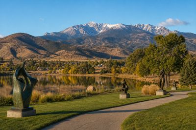 Bronze sculptures along a lakeside path with the Front Range behind, Loveland Colorado