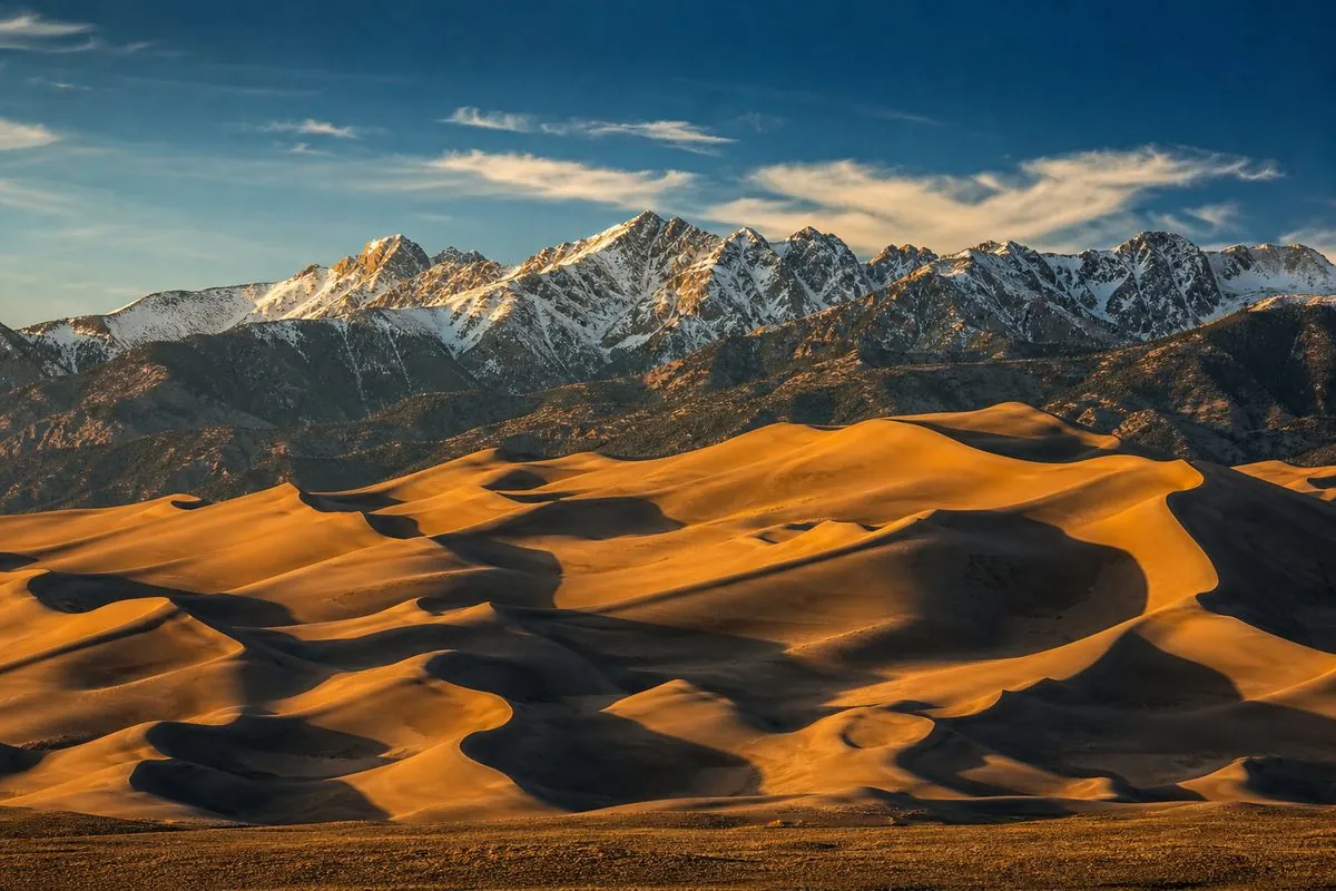 Great Sand Dunes National Park at golden hour with snow-capped Sangre de Cristo Mountains